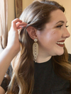 Close-up of pearl chandelier dangle earrings with white and gold beads by Fair Anita