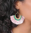 Close-up of a person wearing colorful beaded earrings with pink fringe.