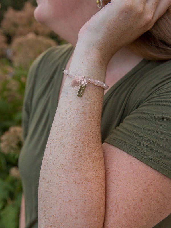 Blush pink beaded elastic bracelet for Mother's Day gift, handcrafted with rose quartz beads and tassel