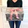 Flat lay of EverBox pink plaid gift box pattern detail with white satin ribbon