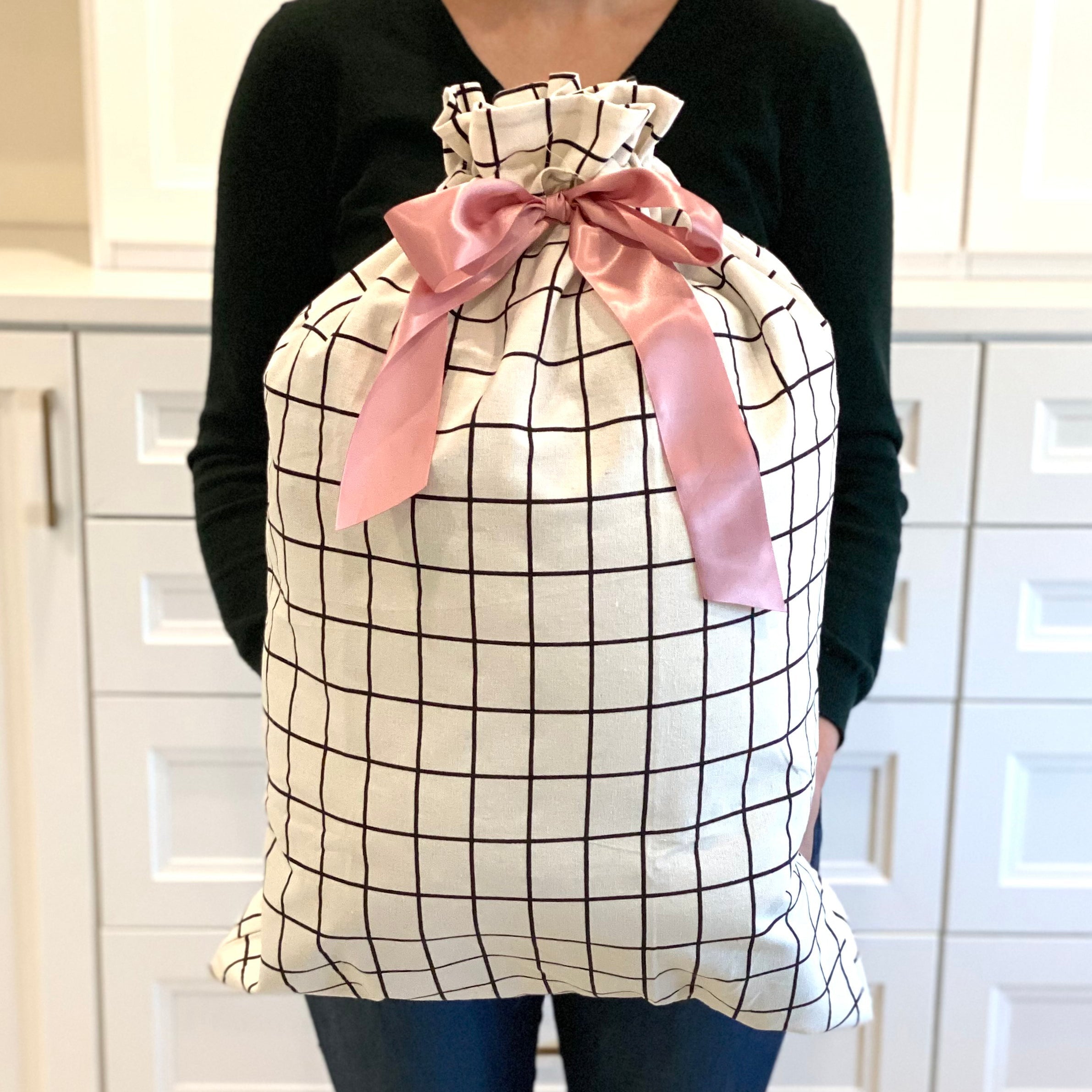 EverWrap reusable sleigh gift bag in black grid pattern styled with wrapped gift inside