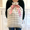 EverWrap reusable sleigh gift bag in black grid pattern styled with wrapped gift inside