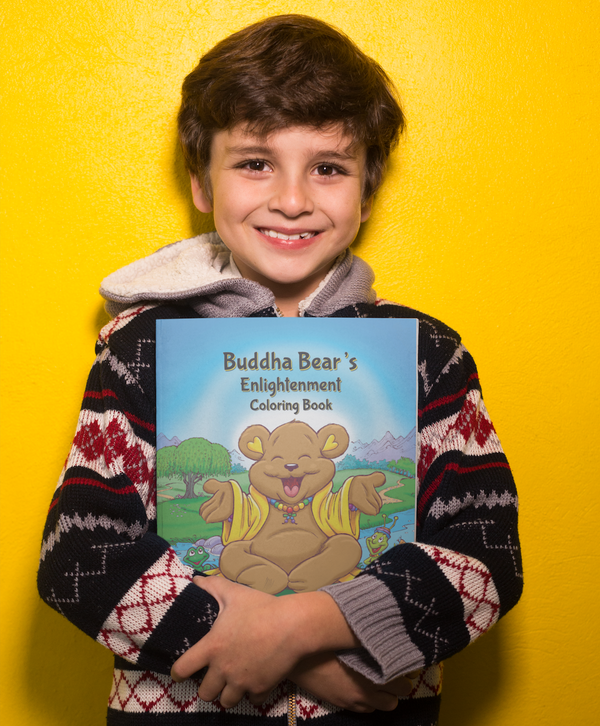 Child holding Buddha Bear's Enlightenment Coloring Book — a mindful and sustainable gift for kids