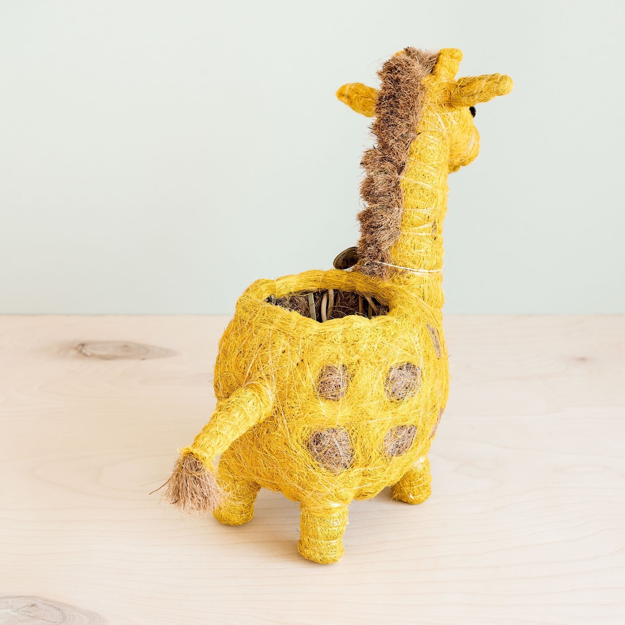 Yellow giraffe-shaped planter on a light background