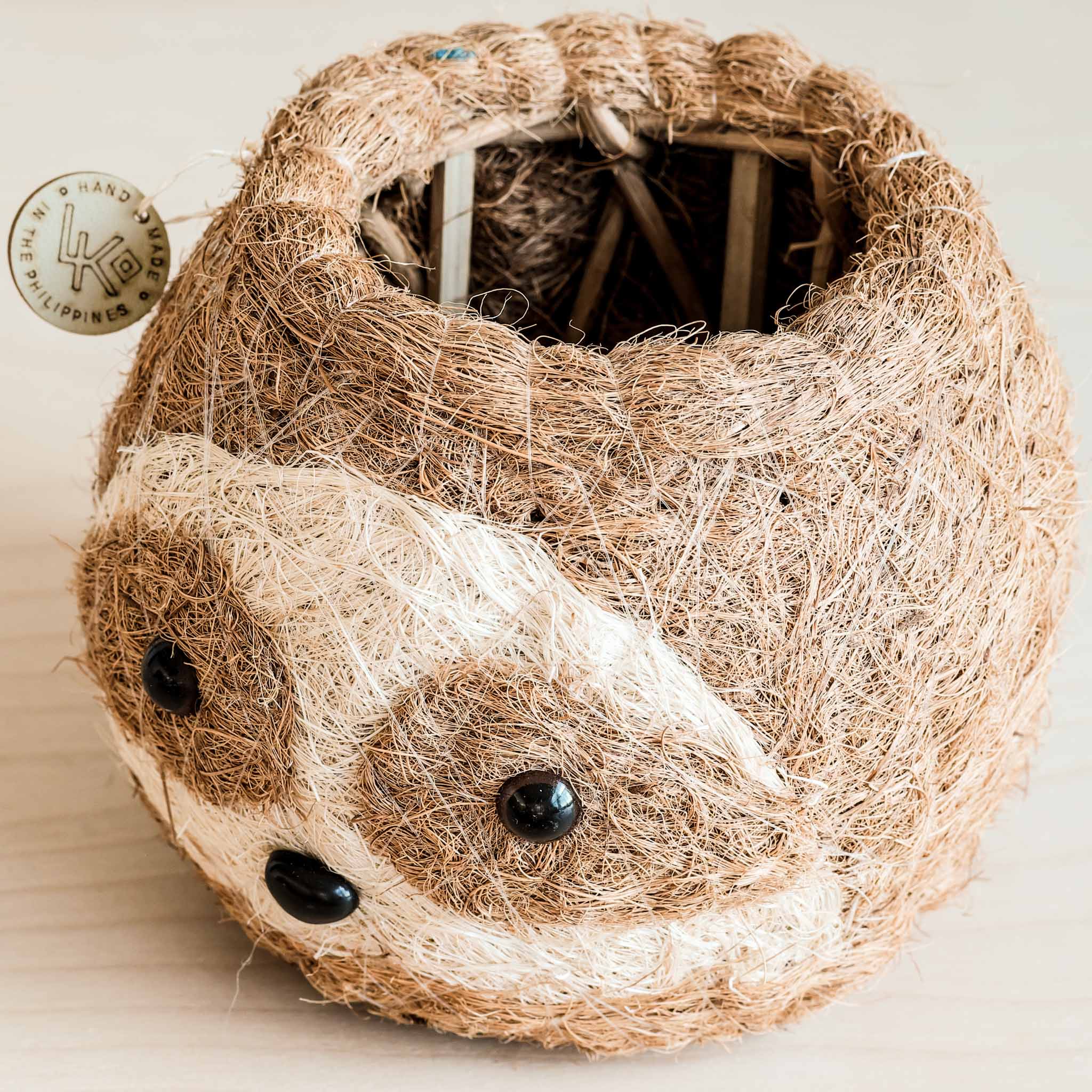 Woven basket made of natural fibers with black stones on a light background