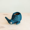 Blue textured plant pot shaped like a fish on a light wooden surface