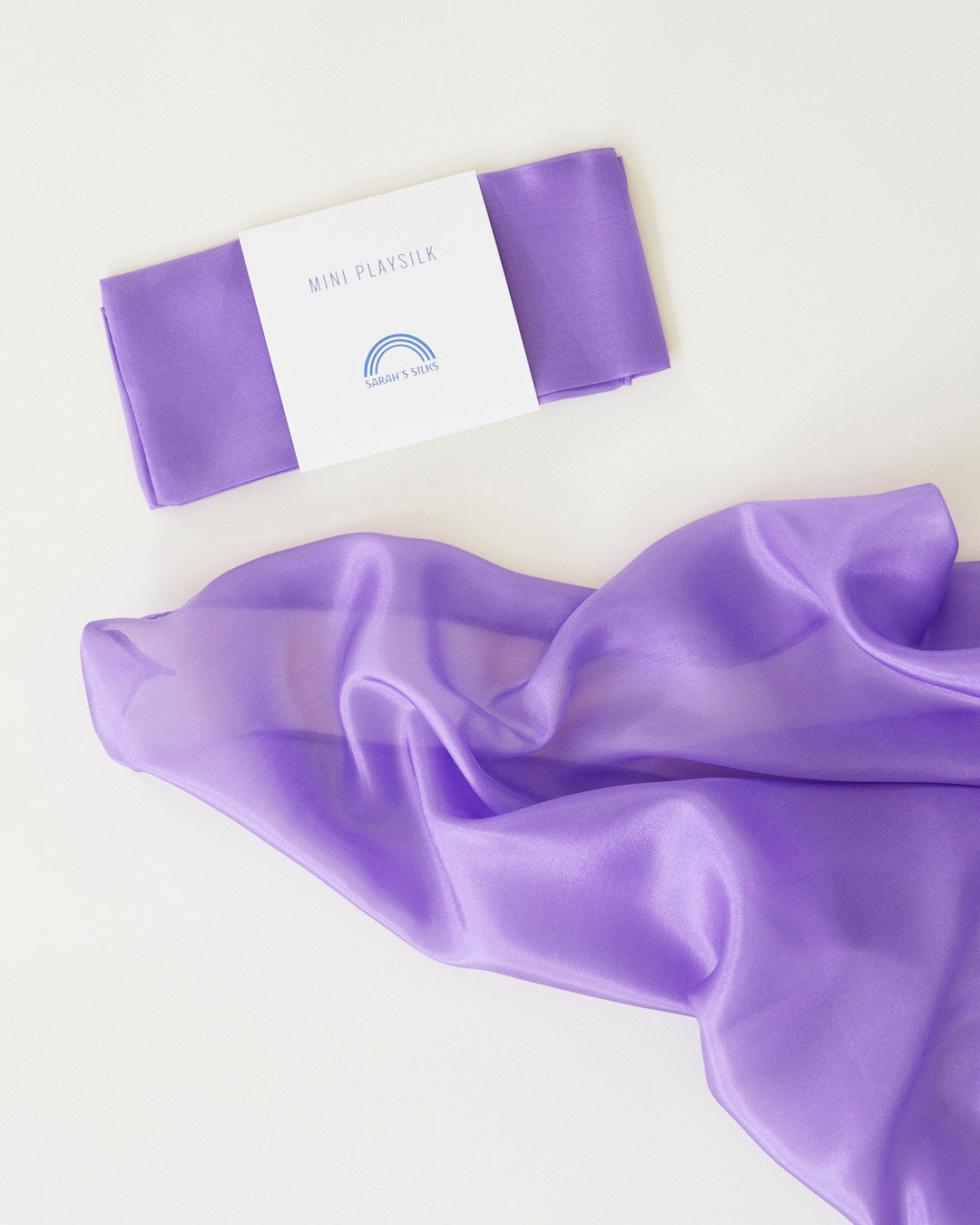 Young child using Sarah's Silks mini playsilks for dress-up and creative sensory play