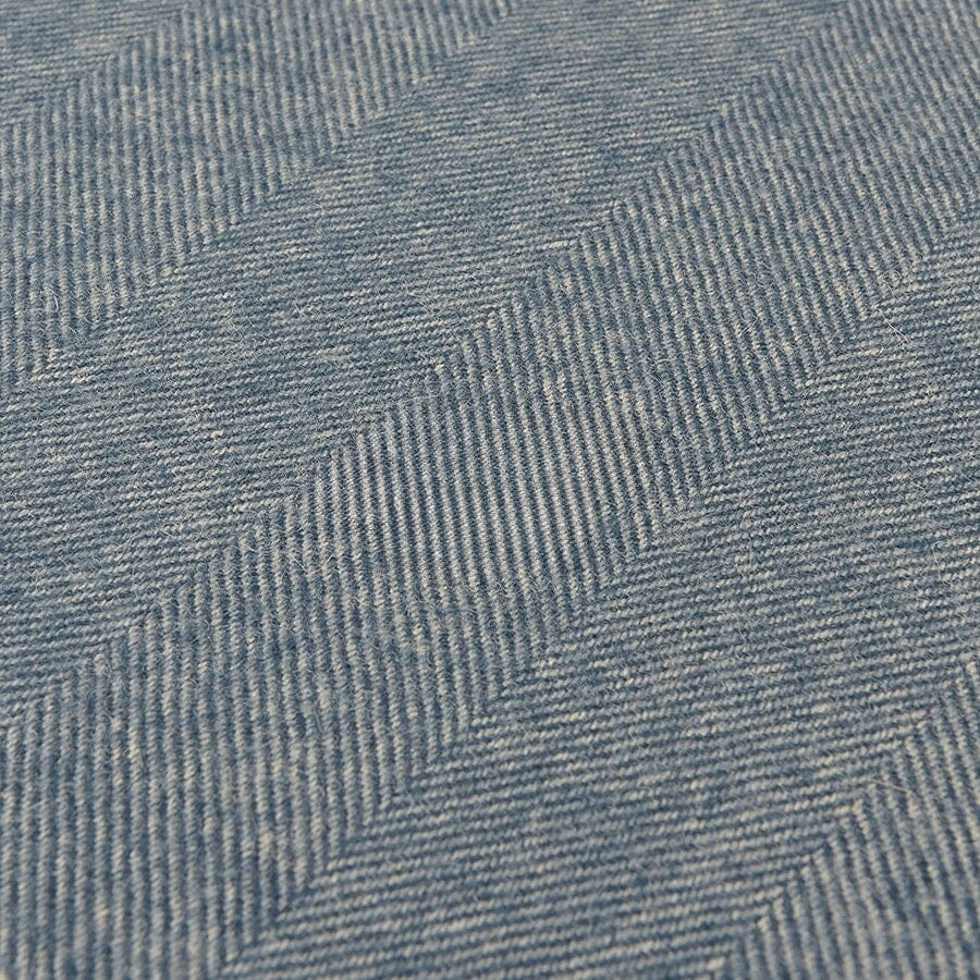 Close-up of blue denim fabric with a herringbone pattern