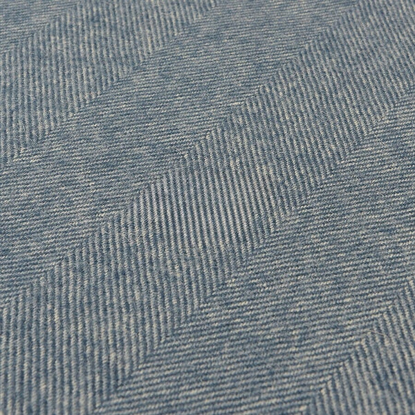 Close-up of blue denim fabric with a herringbone pattern