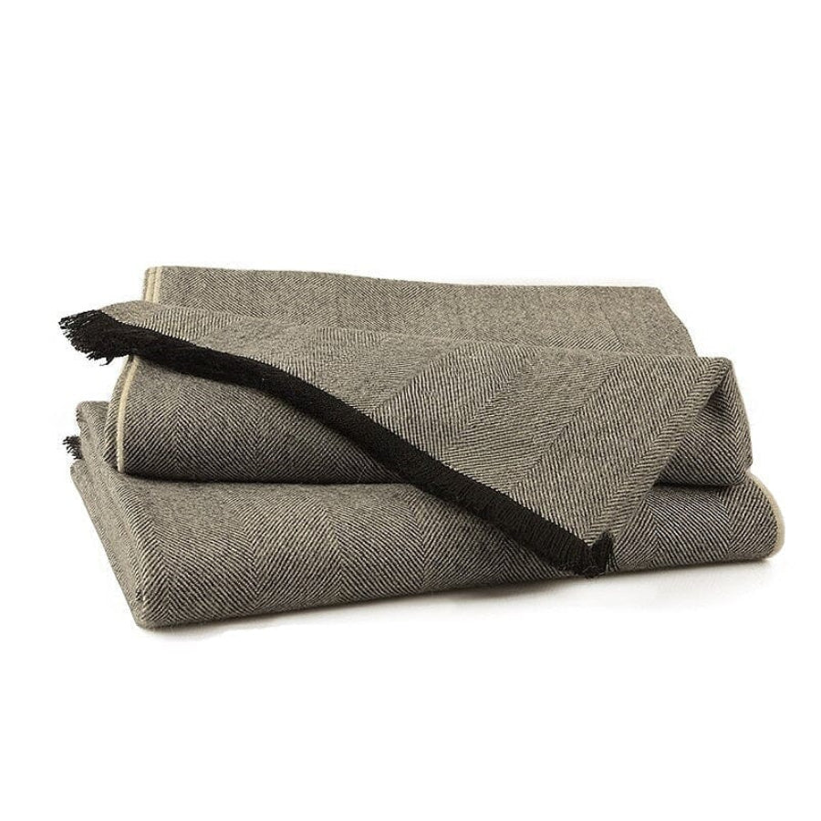 Folded gray blanket with black edges on a white background