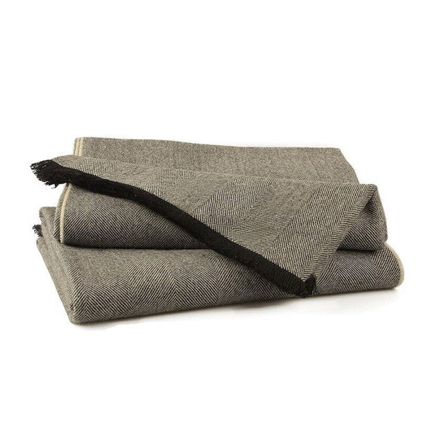 Folded gray blanket with black edges on a white background