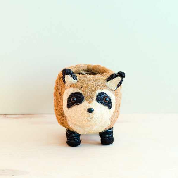 Felted wool toy shaped like a raccoon on a light background