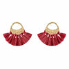 Pair of red tassel earrings with gold circular accents on a white background