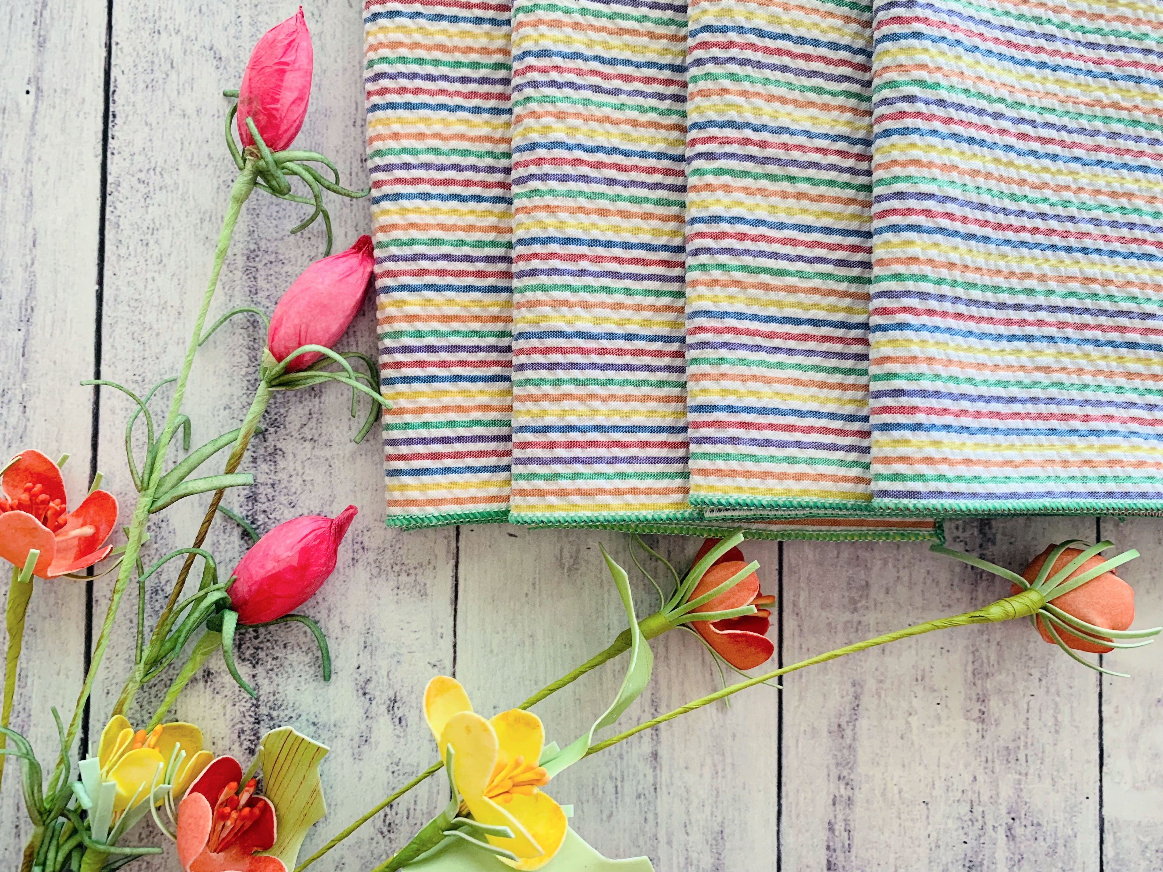 Rainbow seersucker cloth napkins folded and styled on a table, set of four