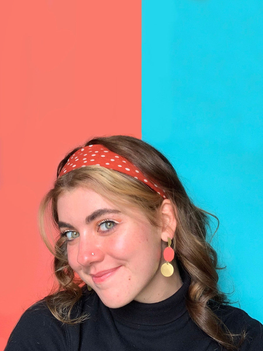 Close-up of red and brass oval fabric earrings handmade by Fair Anita artisans in India