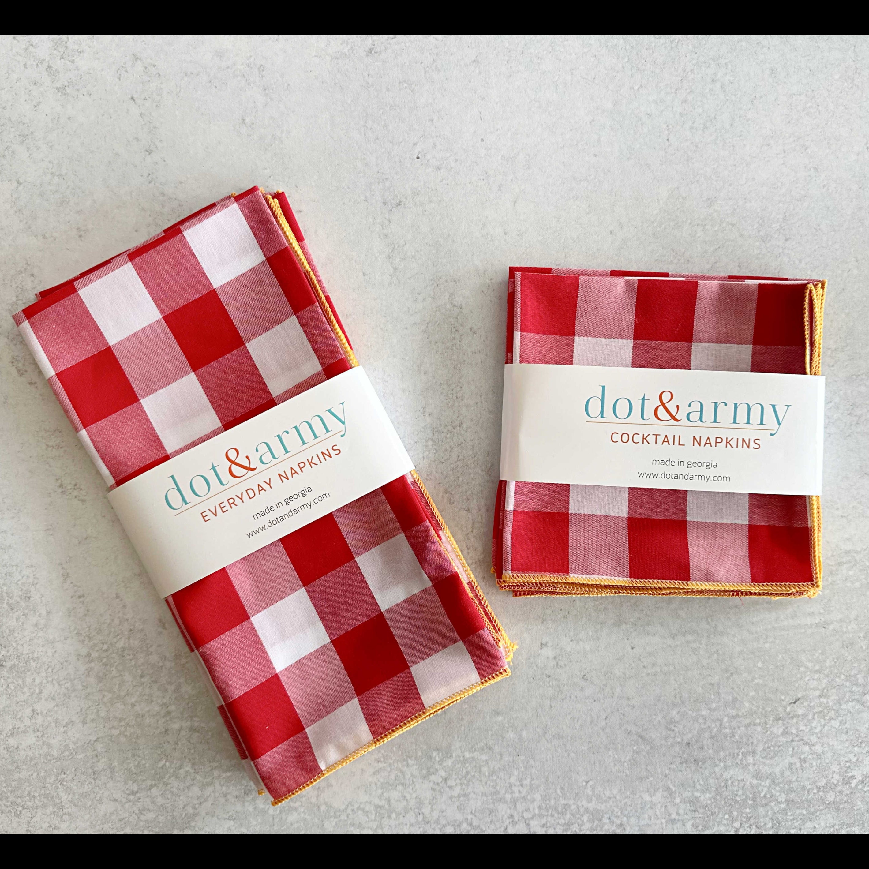 Two packages of red and white checkered napkins with 'dot&army' branding on a light gray background.
