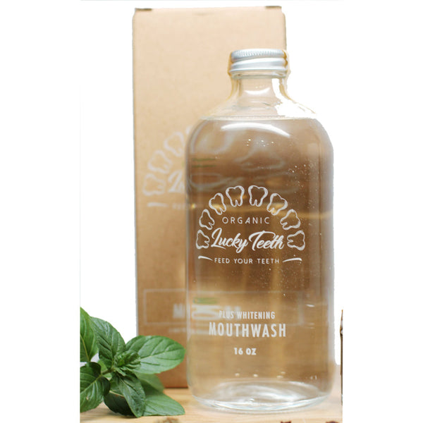Clear glass mouthwash bottle with 'Lucky Teeth' branding on a white background