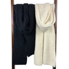 Black and white knitted scarves on a wooden rack against a white background