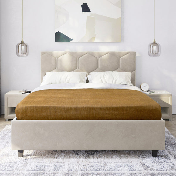 Beige upholstered bed with brown mattress cover in a modern bedroom setting.