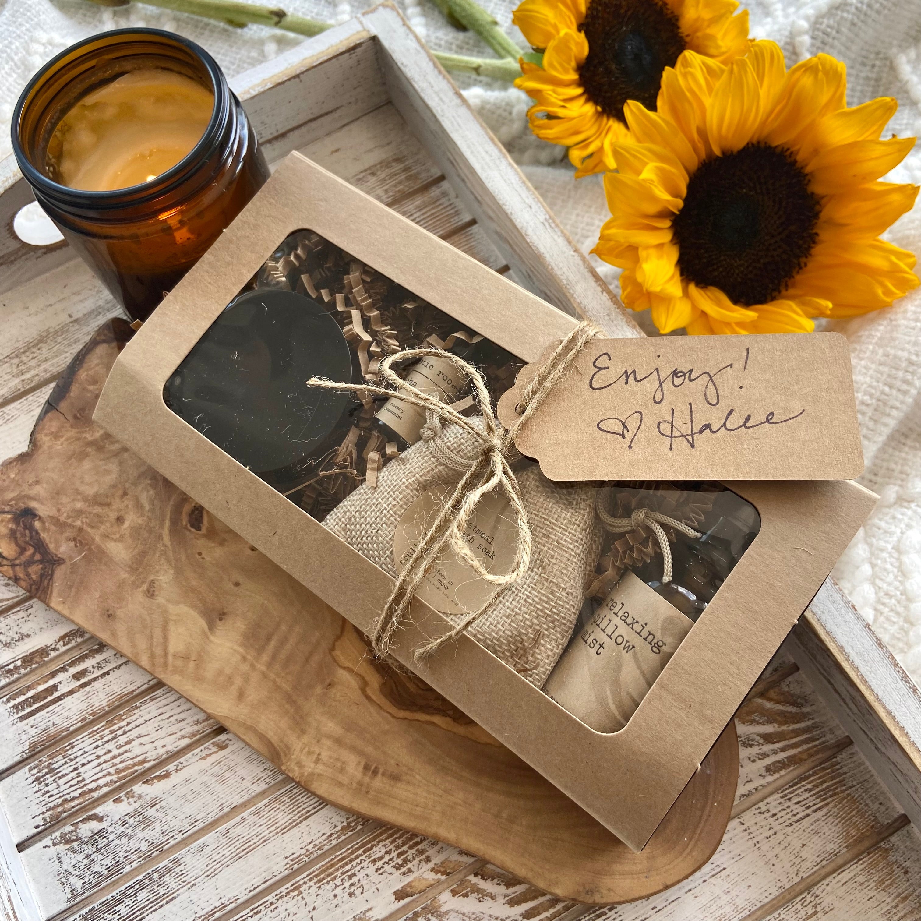 Gift box with a candle and sunflowers on a wooden surface