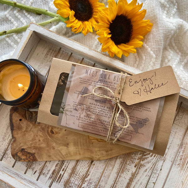 Herbal tea package with a candle and sunflowers on a wooden surface
