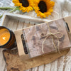 Open book with a candle and sunflowers on a wooden surface