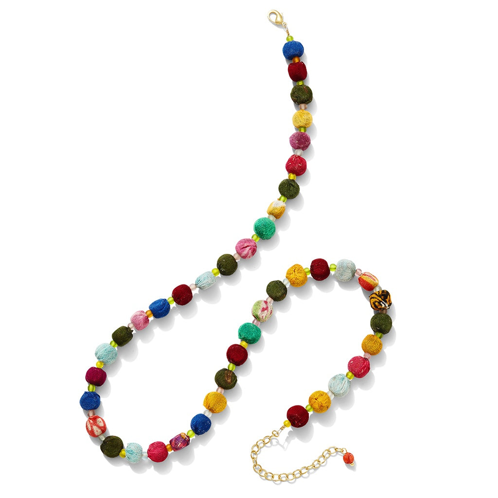 Colorful beaded necklace shaped like a peace sign on a white background