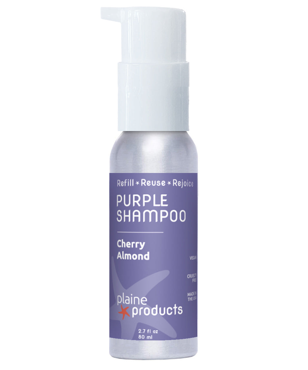 Purple shampoo bottle with cherry almond scent on a white background