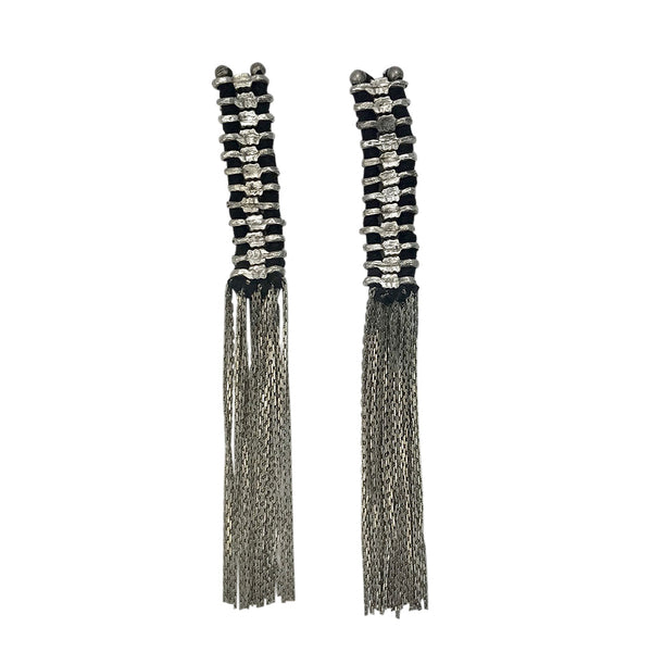 Pair of long tassel earrings with black and silver design on a white background