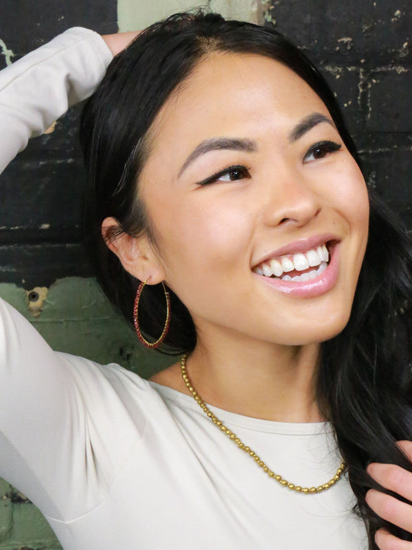 Close-up of upcycled brass round bead artillery necklace on model – Fair Anita for Clozist