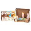 Skout organic cookie packages and a cardboard box with snacks on a gray background