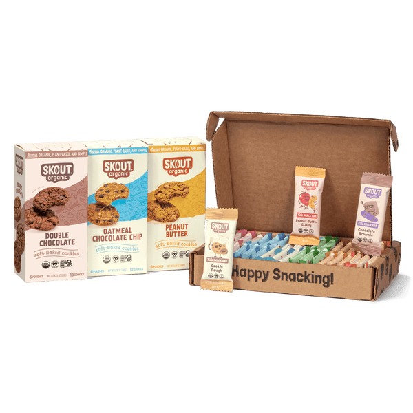 Skout organic cookie packages and a cardboard box with snacks on a gray background