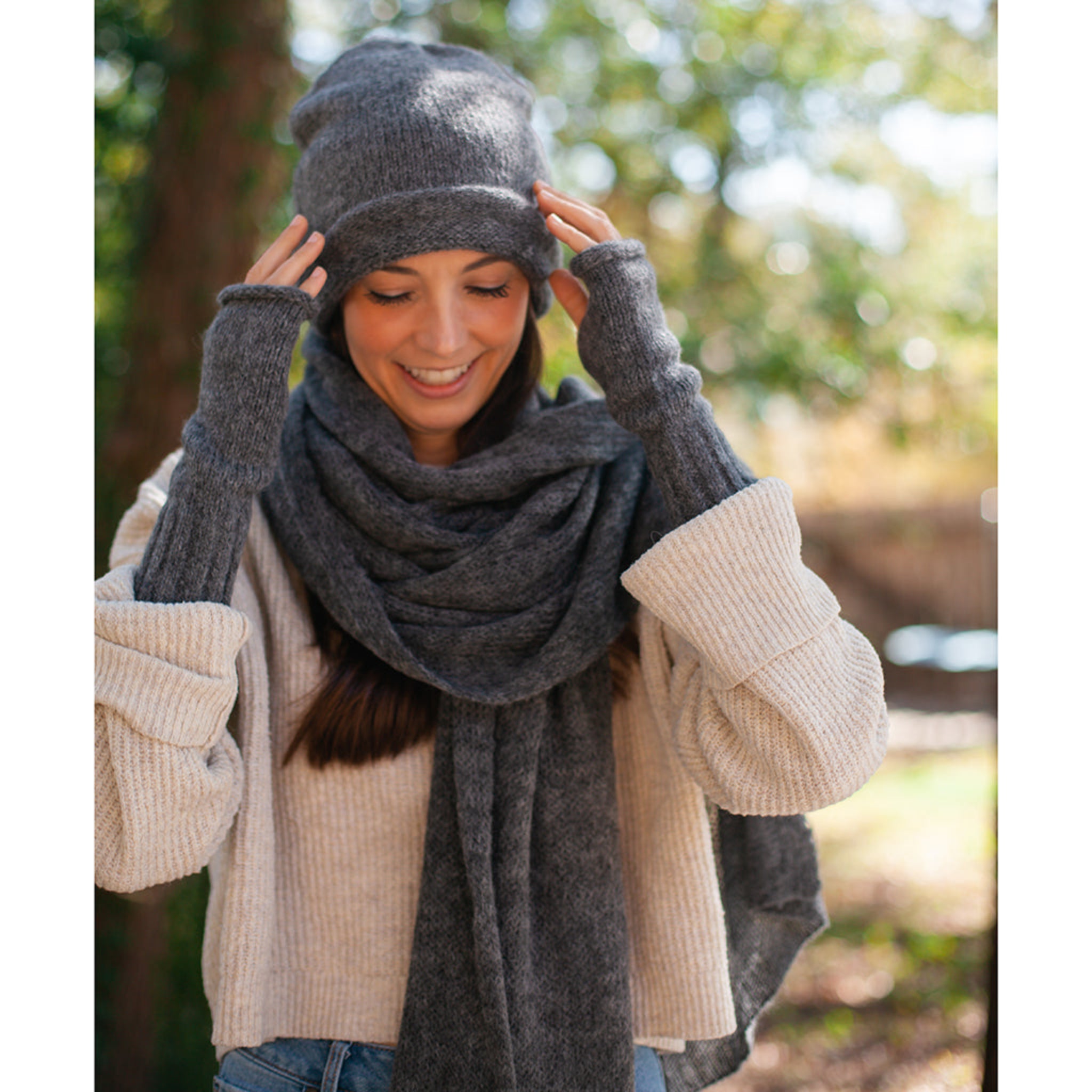 Woman wearing a gray knit hat and scarf outdoors