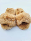 Pair of brown fuzzy slippers on a light blue background