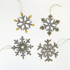 Four snowflake-shaped ornaments with gold and silver details on a white background