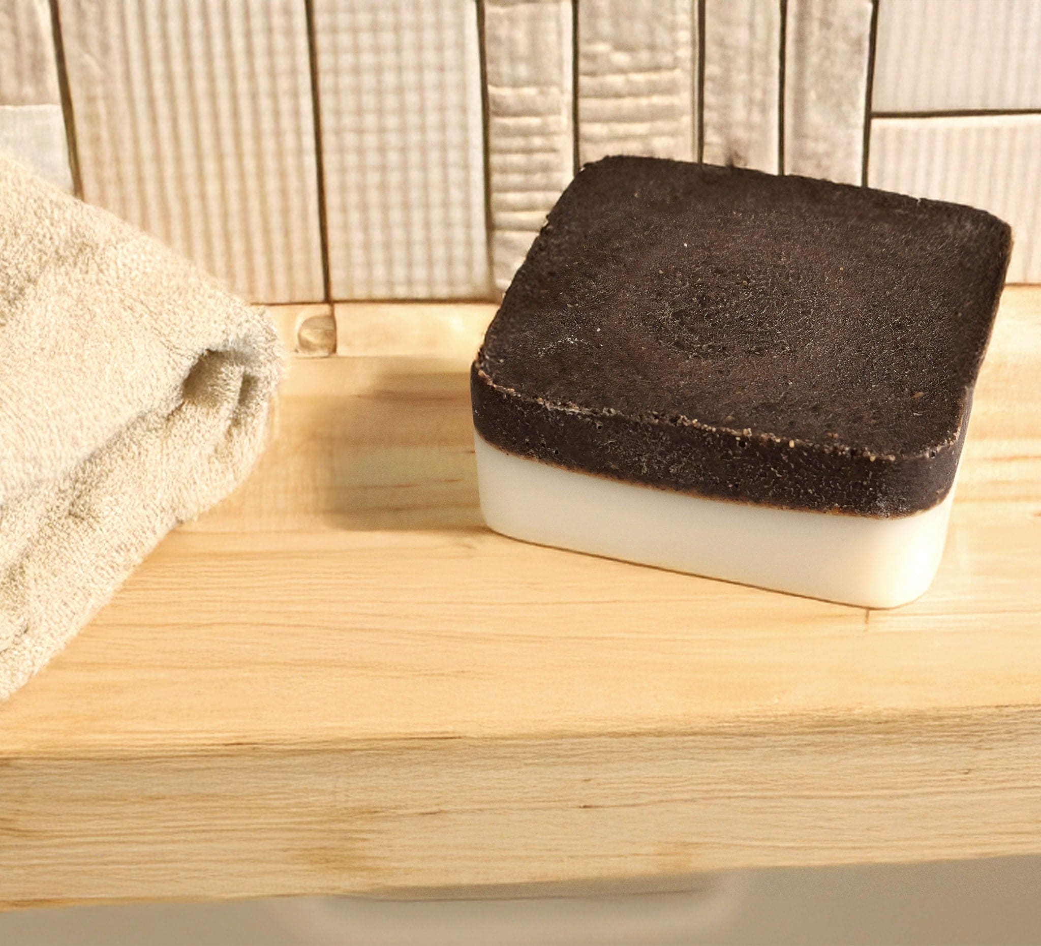 Black and white scrubber on a wooden surface with a towel in the background