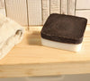 Black and white scrubber on a wooden surface with a towel in the background