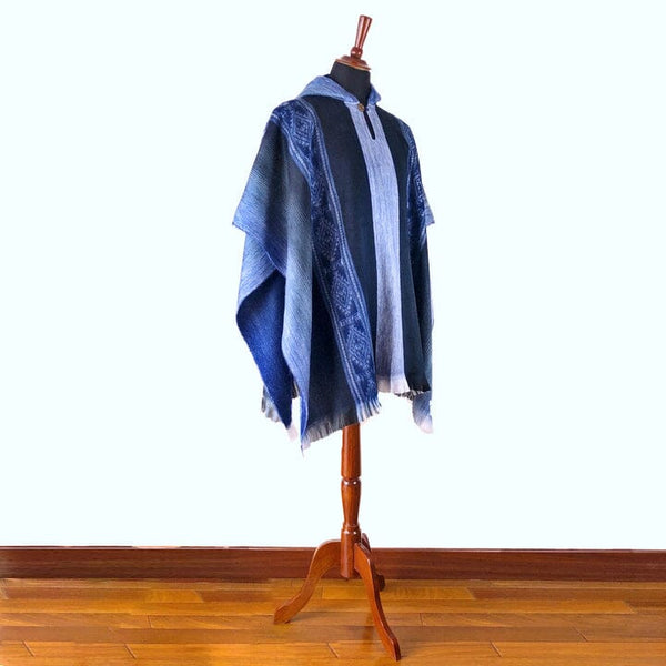 Blue and white patterned shawl draped over a wooden mannequin on a white background