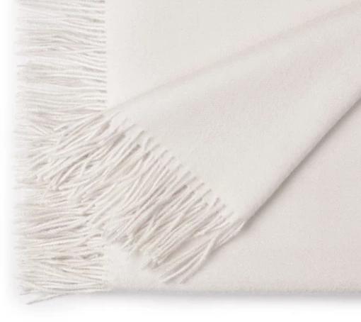 White blanket with fringe on a white background