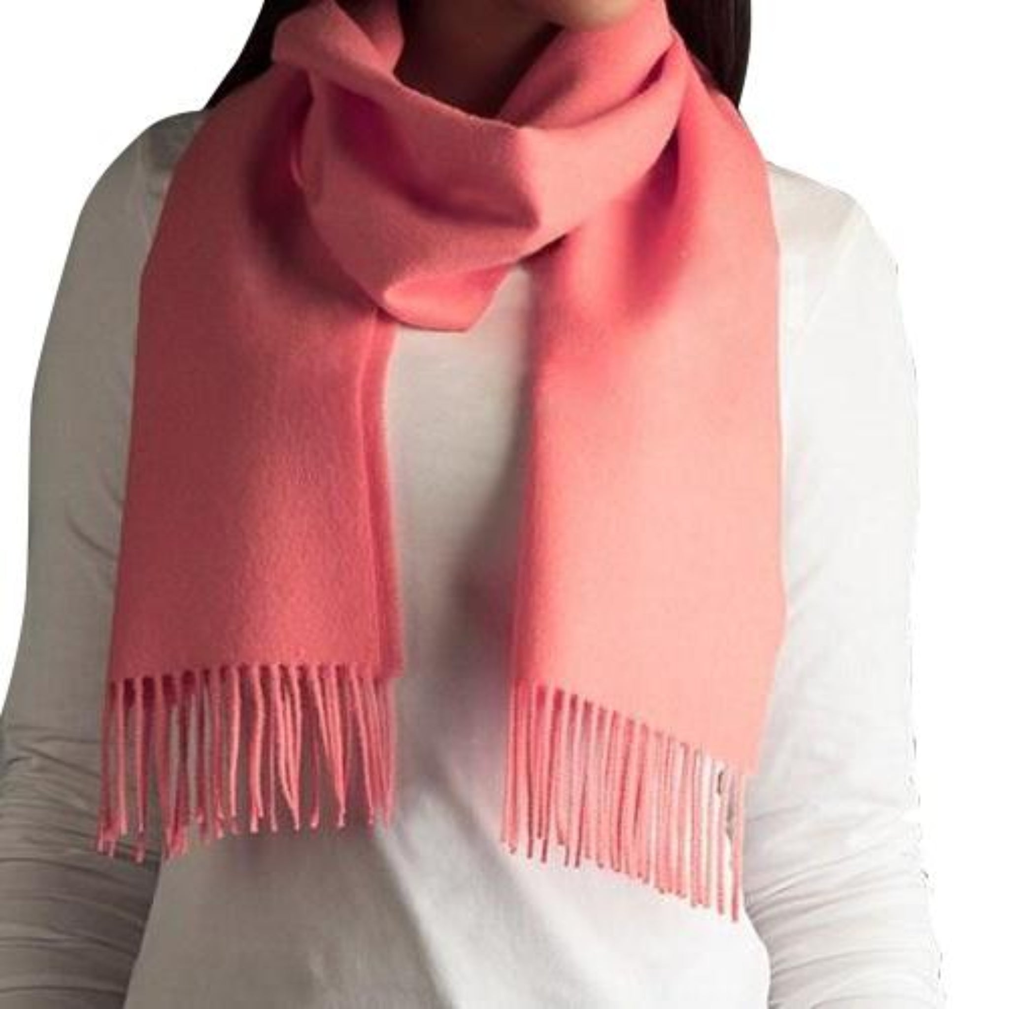 Person wearing a pink scarf with fringes on a white background