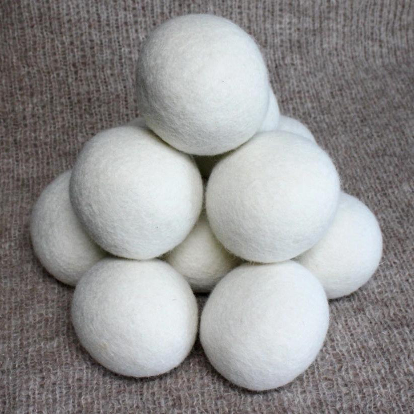 White dryer balls stacked on a textured brown surface