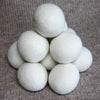 White dryer balls stacked on a textured brown surface