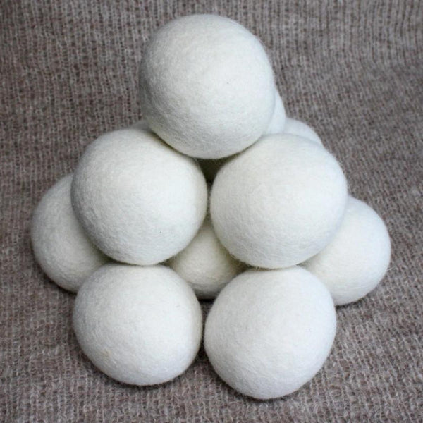 White dryer balls stacked on a textured brown surface