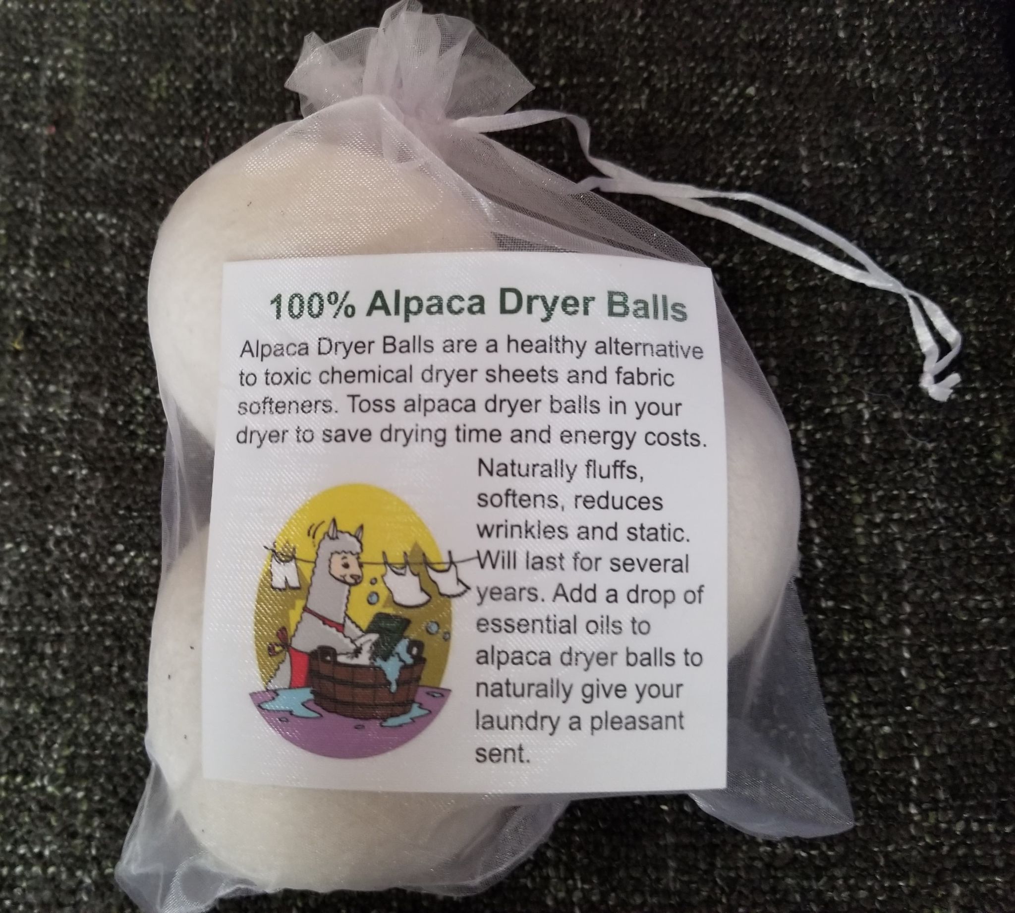 Alpaca dryer balls in a clear bag with a label on a dark textured background