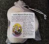Alpaca dryer balls in a clear bag with a label on a dark textured background