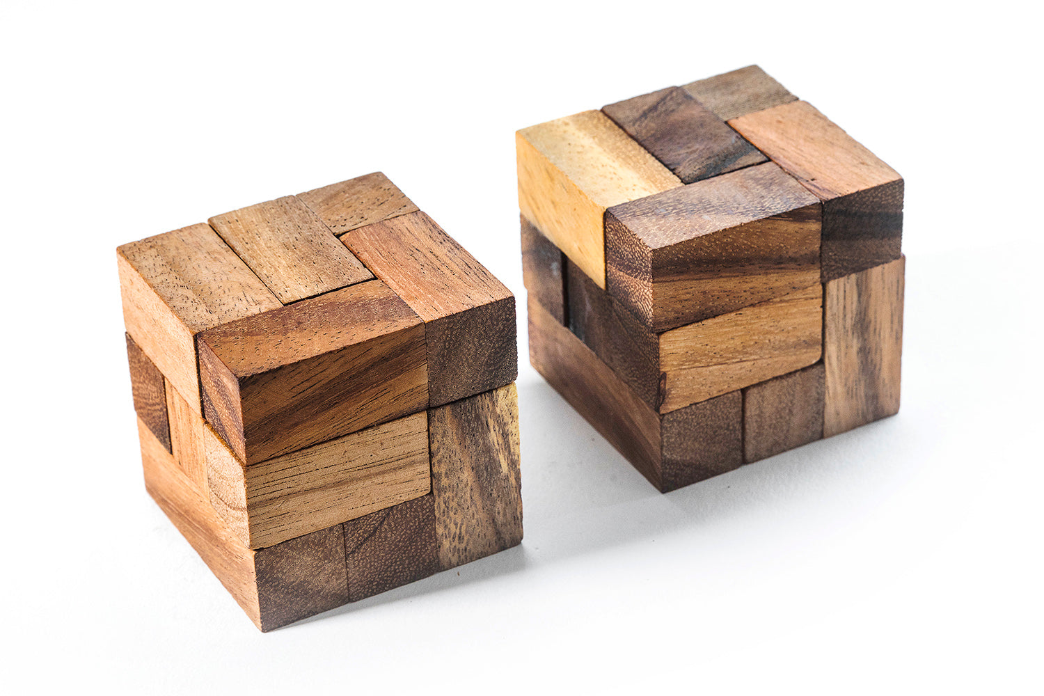 Two wooden puzzle cubes on a white background