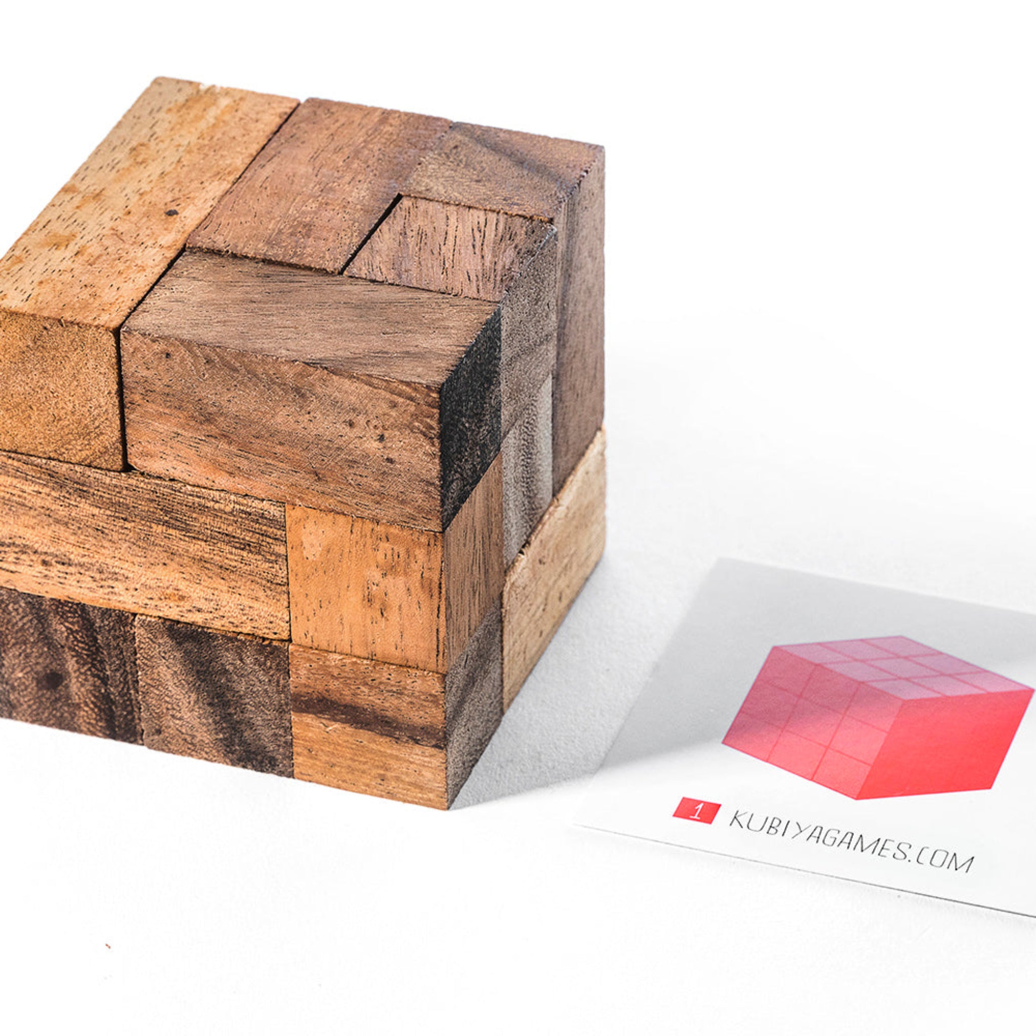 Wooden puzzle cube with a branded card on a white background