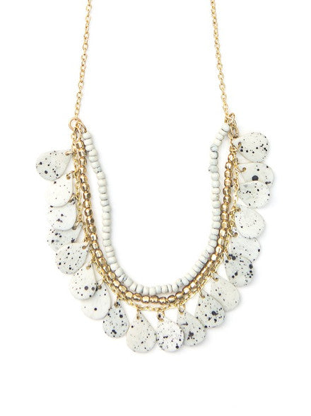 Close-up of speckled upcycled bone and brass-plated recycled metal chain necklace detail