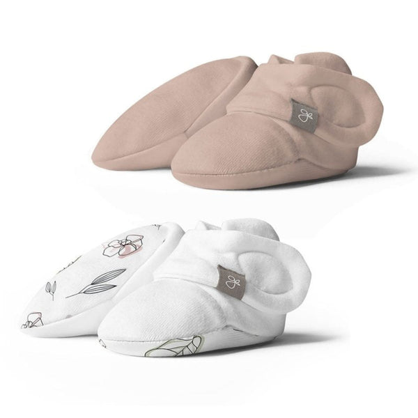 Pair of beige baby booties and a pair of white baby socks with floral designs on a white background.