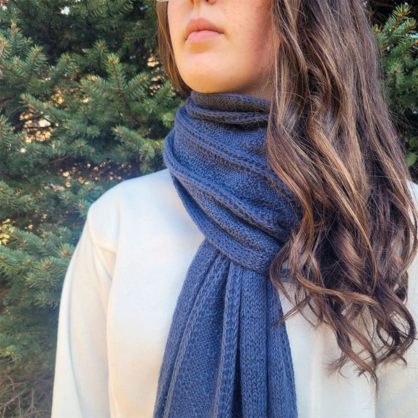 Person wearing a blue scarf with a blurred natural background